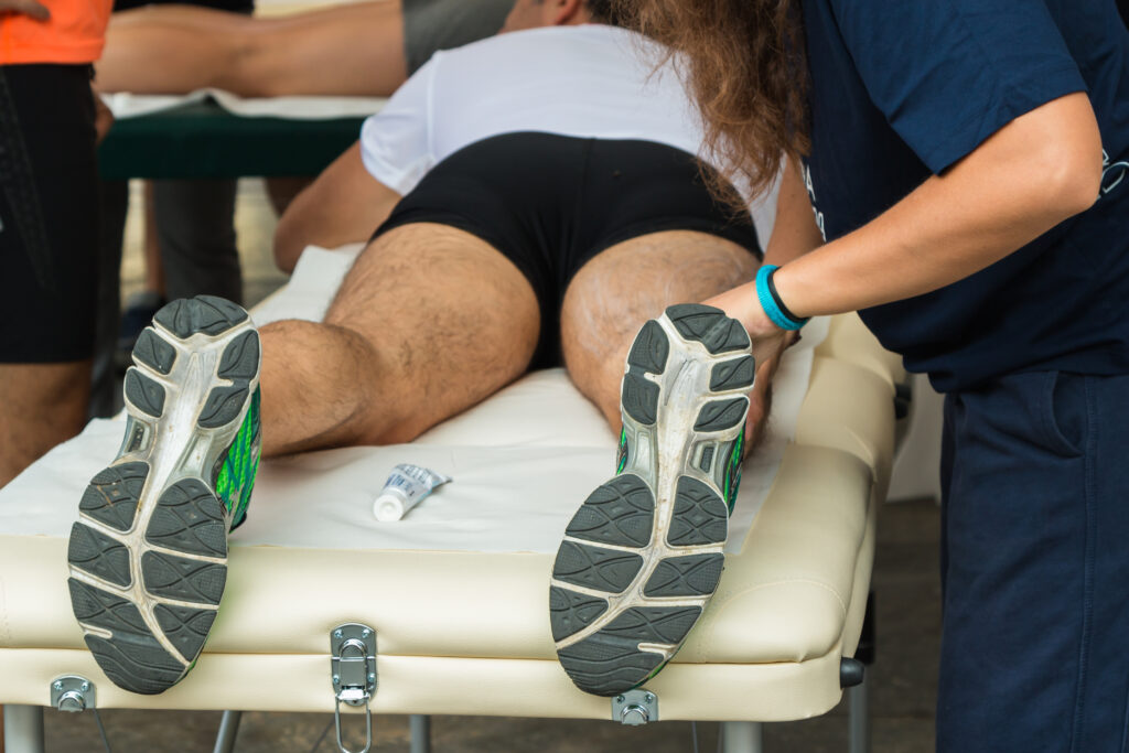 A man lies on his stomach and receives treatment in his legs for hamstring stiffness.