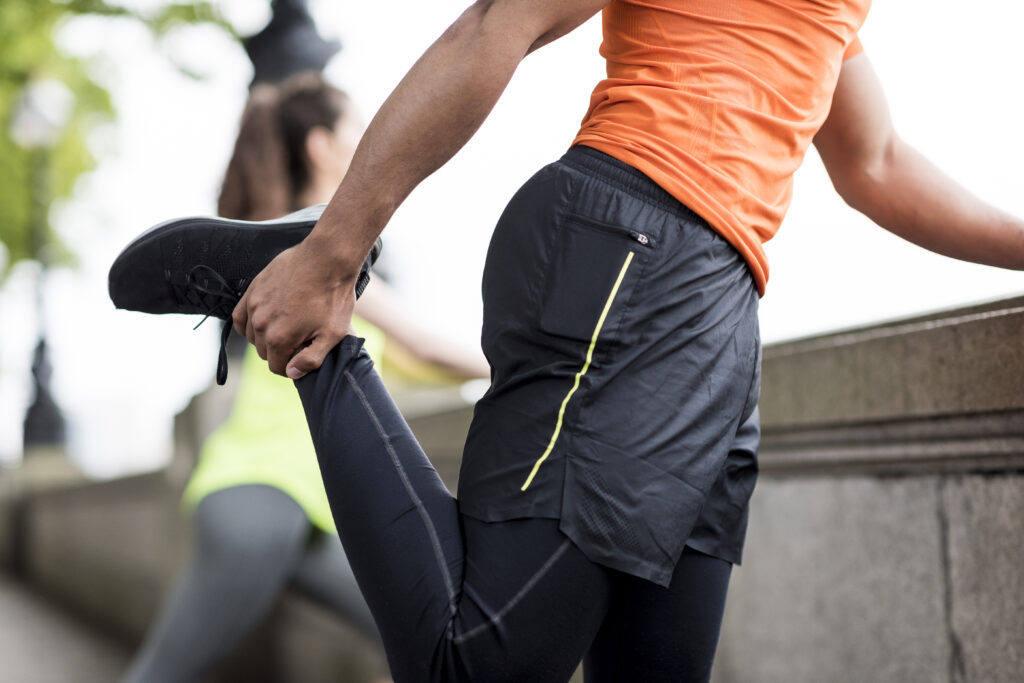 A male runner stretches his hamstrings after a run.